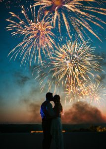 Kissing under fireworks at dusk